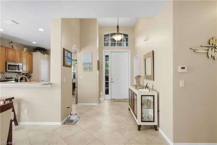 Foyer entrance featuring a high ceiling, light tile patterned floors, and recessed lighting