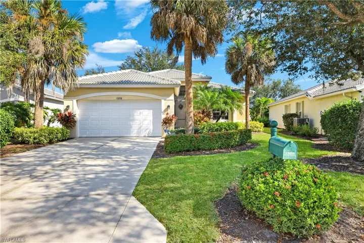 Single story home featuring stucco siding, concrete driveway, an attached garage, a tile roof, and a front lawn