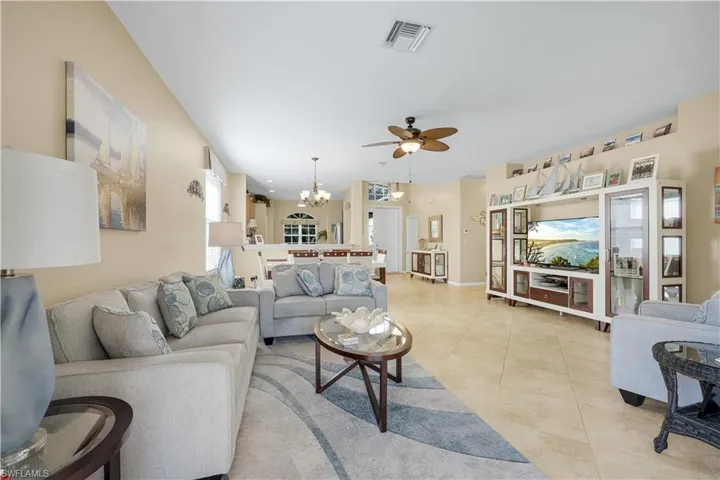 Living area featuring a chandelier, ceiling fan, and light tile patterned floors