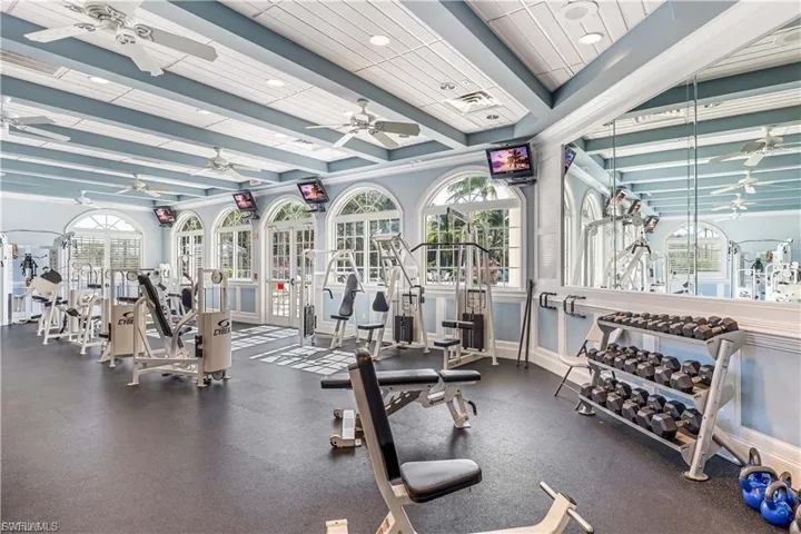 Workout area with a ceiling fan, beam ceiling, and recessed lighting