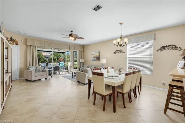 Dining room featuring ceiling fan, light tile patterned floors, and a chandelier