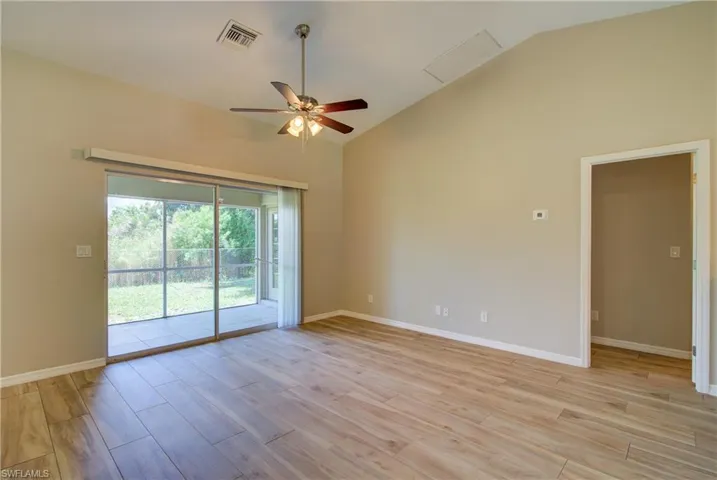 Spare room featuring ceiling fan, light wood-style floors, and high vaulted ceiling