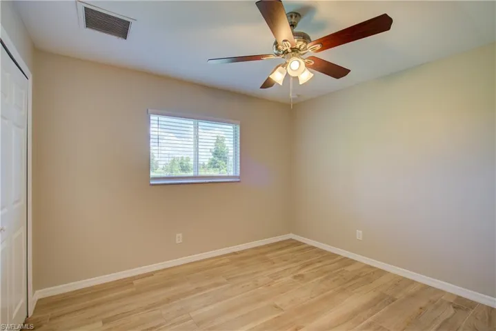 Unfurnished bedroom with light wood-type flooring, a closet, and ceiling fan