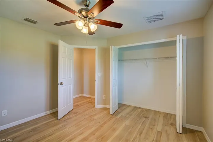 Unfurnished bedroom with light wood-style floors, ceiling fan, and a closet