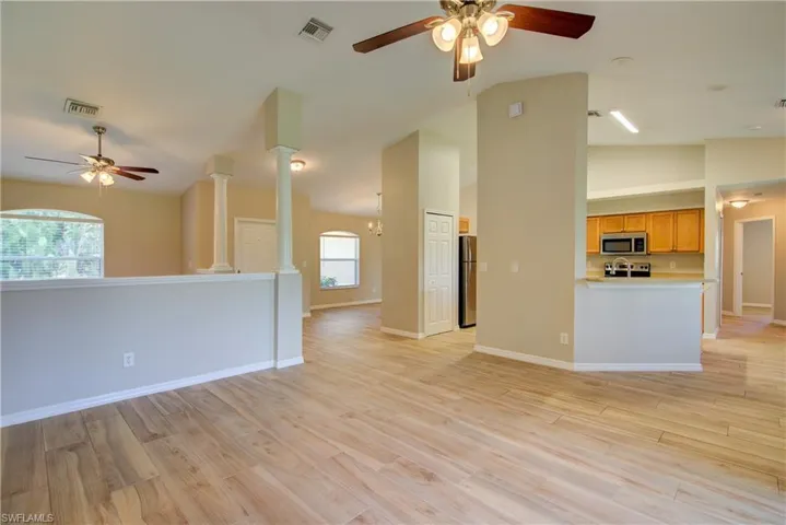 Unfurnished living room featuring a ceiling fan, light wood-type flooring, and high vaulted ceiling
