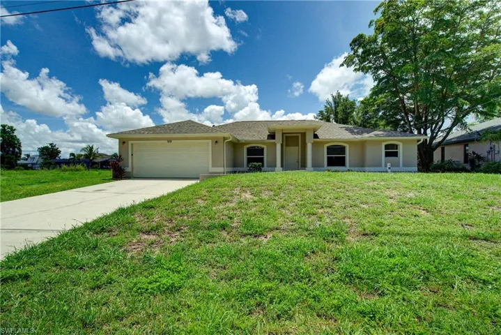 Ranch-style house with an attached garage, concrete driveway, stucco siding, a front yard, and roof with shingles