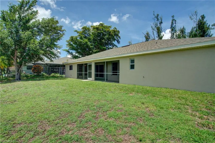 View of grassy yard with a sunroom
