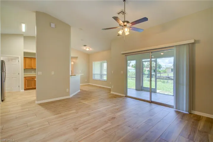 Unfurnished living room with vaulted ceiling, wood tiled floors, and a ceiling fan