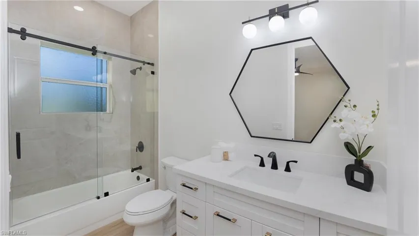 Full bath with vanity and bath / shower combo with glass door