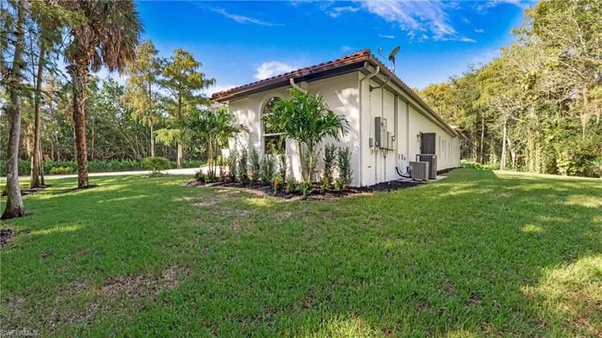 View of side of home with a lawn and stucco siding