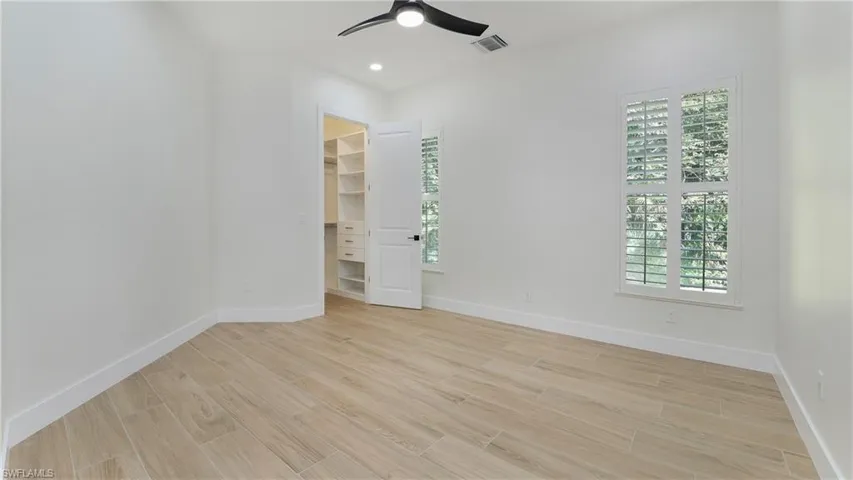 Empty room featuring wood tiled floors, recessed lighting, and a ceiling fan
