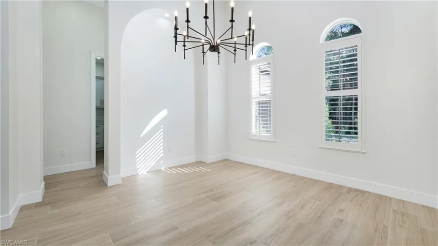 Unfurnished dining area featuring light wood-style floors and a chandelier