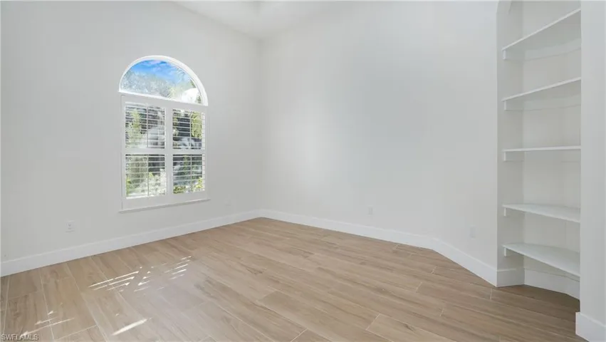 Empty room with wood finish floors and built in shelves