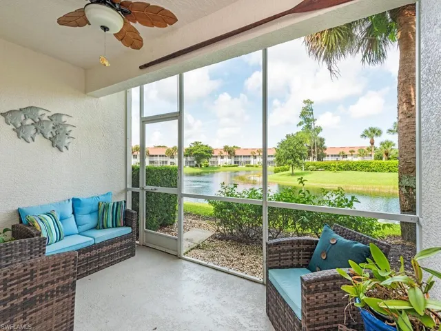Sunroom with ceiling fan and a water view