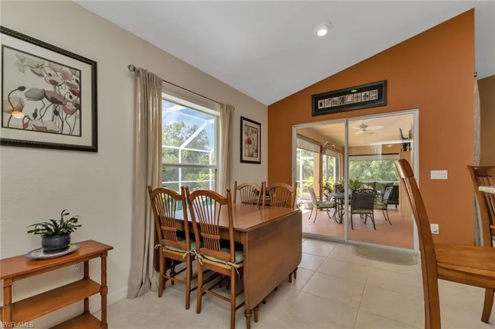 Dining room with light tile patterned floors, a healthy amount of sunlight, and lofted ceiling