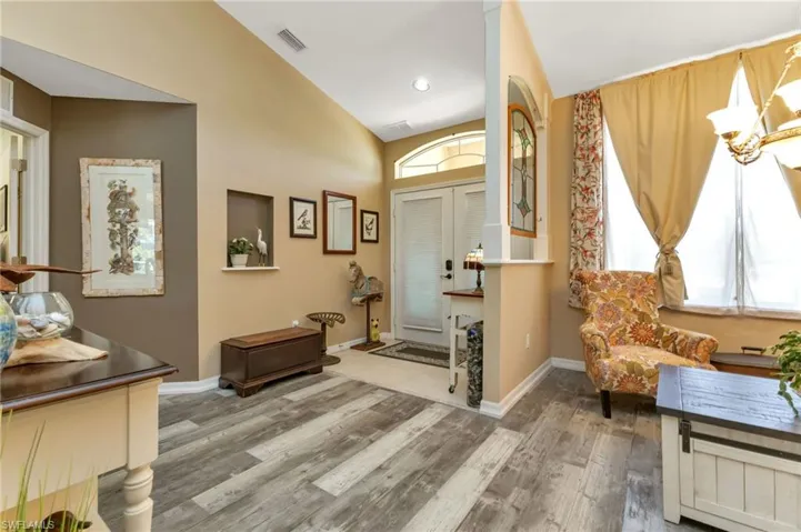 Entryway featuring plenty of natural light, lofted ceiling, and hardwood / wood-style floors
