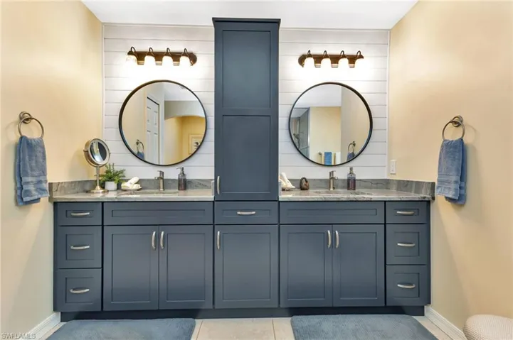 Bathroom with dual vanity and tile patterned floors