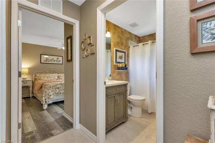 Bathroom featuring vanity, tile patterned floors, ceiling fan, and toilet