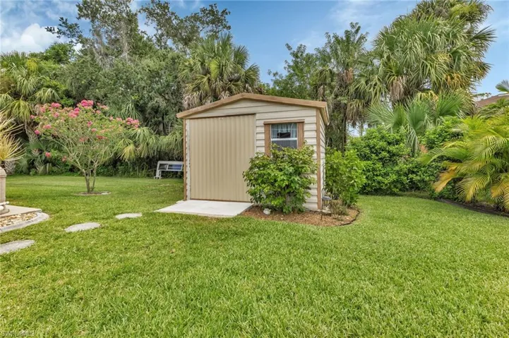 View of outbuilding featuring a lawn
