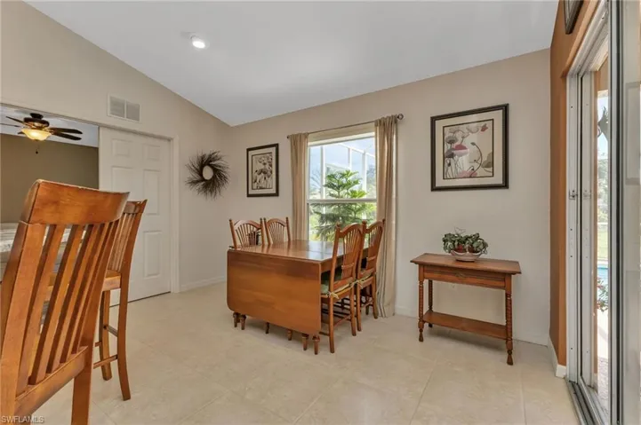 Tiled dining room featuring lofted ceiling and ceiling fan