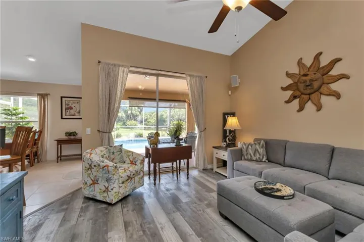 Living room featuring high vaulted ceiling, ceiling fan, and hardwood / wood-style floors