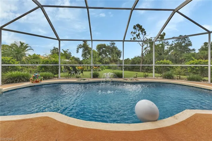 View of swimming pool featuring glass enclosure