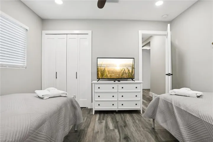 Bedroom featuring dark wood-type flooring, ceiling fan, and a closet