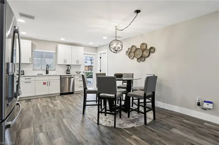 Dining space with sink, an inviting chandelier, and hardwood / wood-style floors