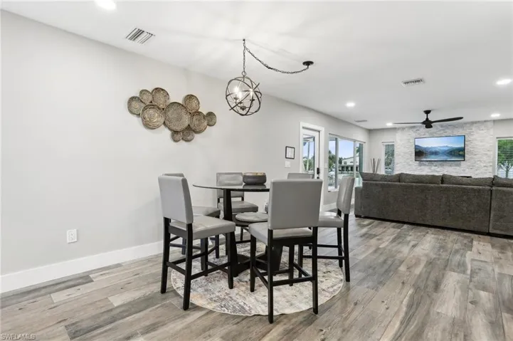 Dining space featuring ceiling fan with notable chandelier and hardwood / wood-style floors
