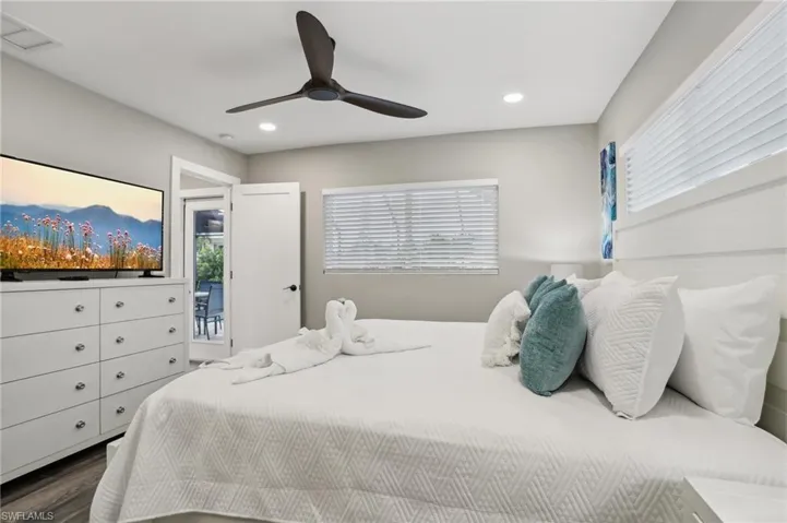 Bedroom featuring hardwood / wood-style flooring, ceiling fan, and access to exterior