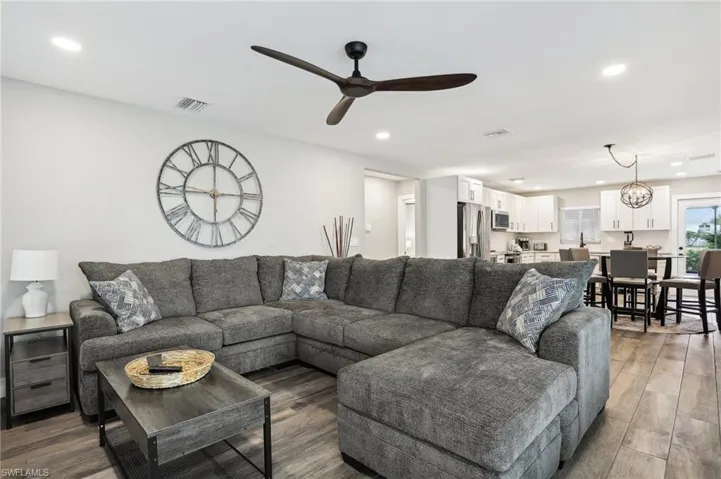 Living room featuring wood-type flooring and ceiling fan with notable chandelier