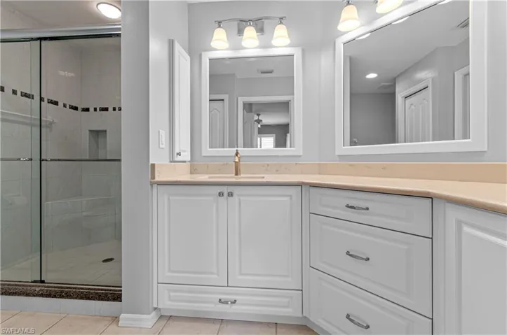 Bathroom featuring vanity, tile patterned flooring, and walk in shower