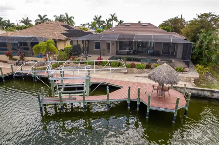 Aerial view of dock and boat lift, with accessible paver ramp from pool enclosure to dock on the right.