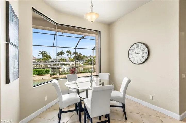 Casual kitchen dining nook with mitered window overlooking the pool.