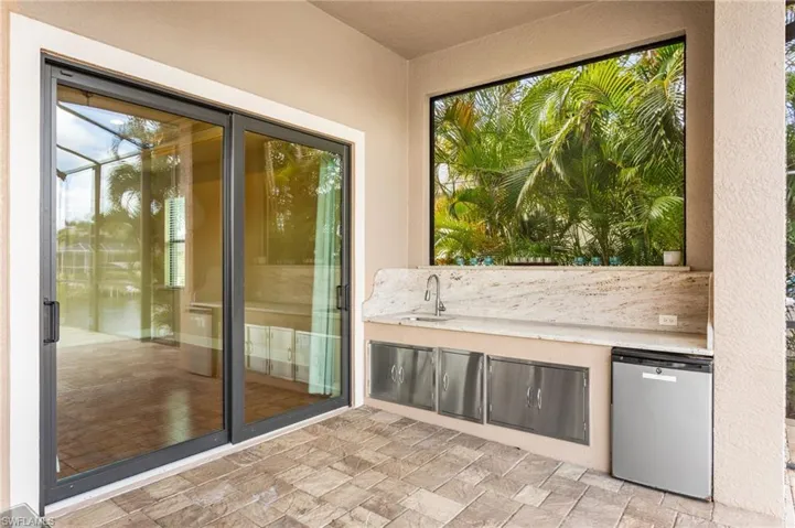 Covered outdoor kitchen space on Lanai with impact sliding doors to Master Suite.