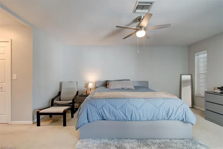 Bedroom with light colored carpet and ceiling fan