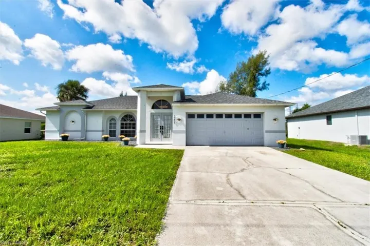 Single story home with stucco siding, a front lawn, and a garage