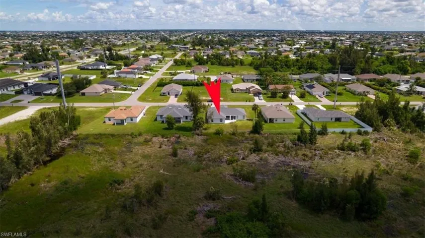 Aerial view of property and surrounding area with nearby suburban area