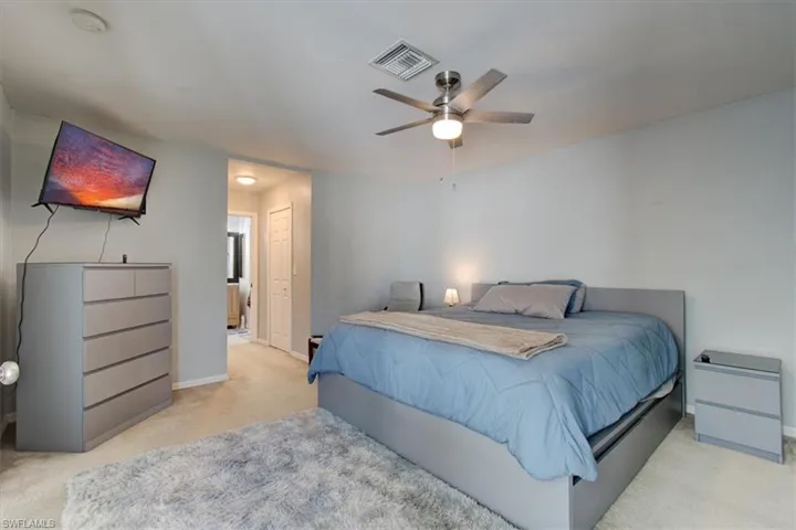 Bedroom with carpet, ceiling fan, and ensuite bathroom