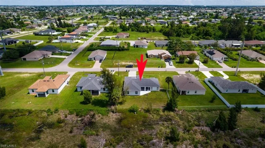 Aerial view of property and surrounding area featuring nearby suburban area