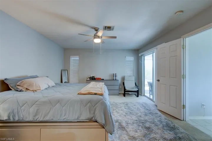 Bedroom with a ceiling fan and light carpet