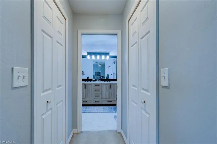 Hallway with tile patterned floors and a textured wall