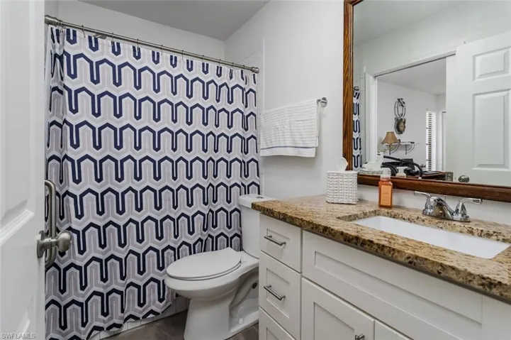 Full guest bath featuring a shower with curtain and vanity
