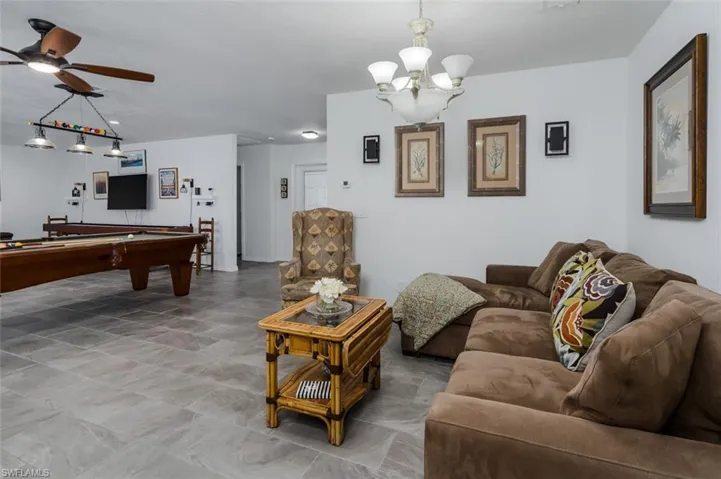 Living area featuring billiards table, suspended lighting, and a ceiling fan