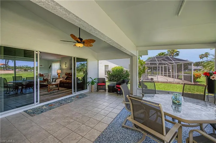Covered patio featuring an outdoor dining area, a screened enclosure, and sliding glass doors
