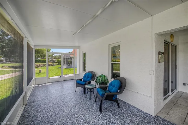 Screened lanai featuring a textured epoxy floor, white paneled ceiling, and direct patio access