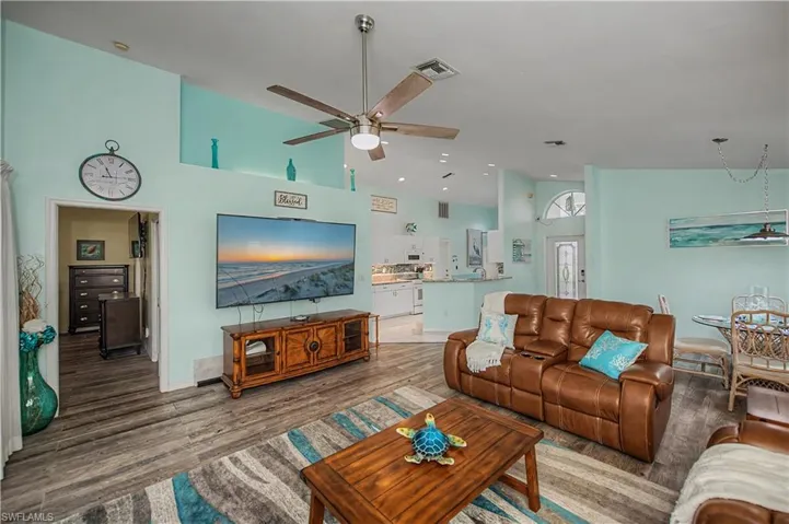 Spacious living area featuring high vaulted ceilings, wood-finish flooring, and an open concept layout
