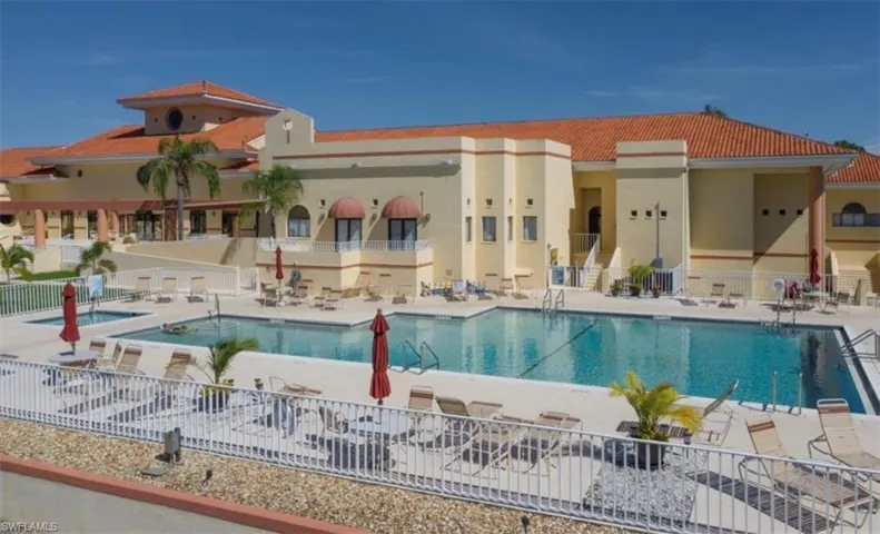 Expansive outdoor aquatic area featuring a large swimming pool, two smaller pools, and extensive surrounding deck space