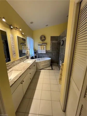 Bathroom featuring a double vanity with granite-style countertop and dual undermount sinks