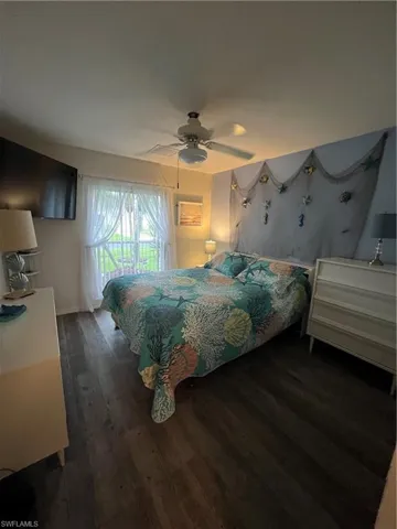 Bedroom featuring wood-finish flooring, a ceiling fan, and a window with sheer curtains